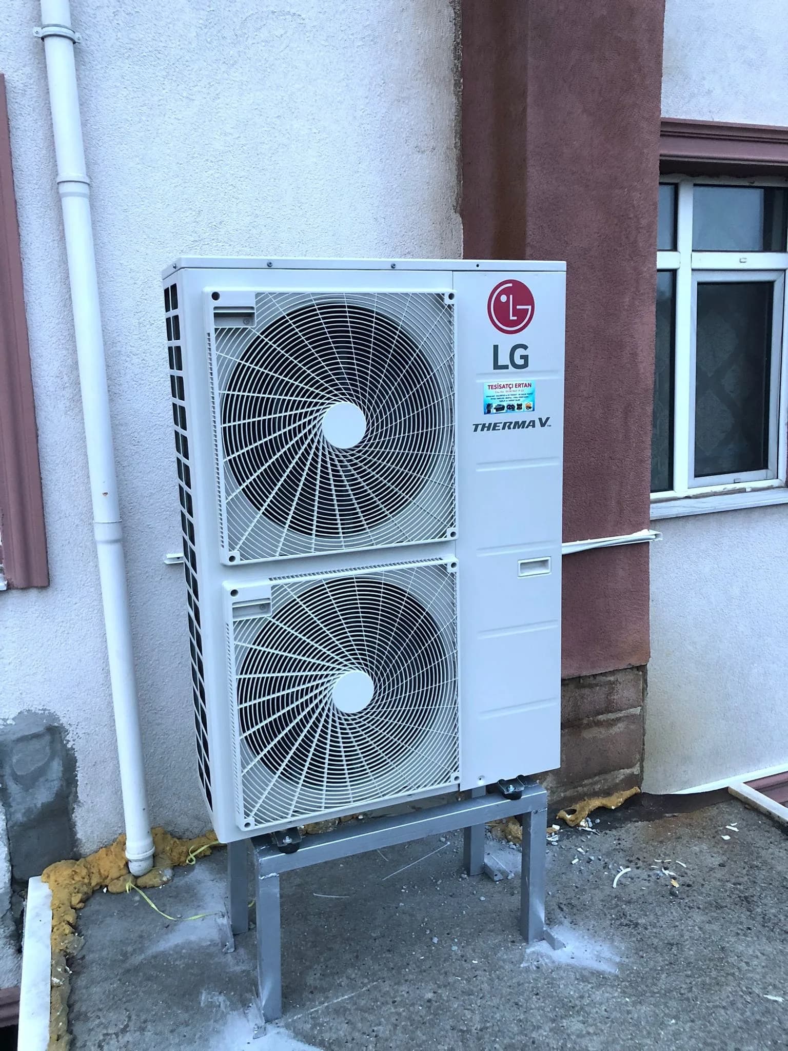 Duvara kaide üzerine monte edilmiş LG Therma V dış ünitesi